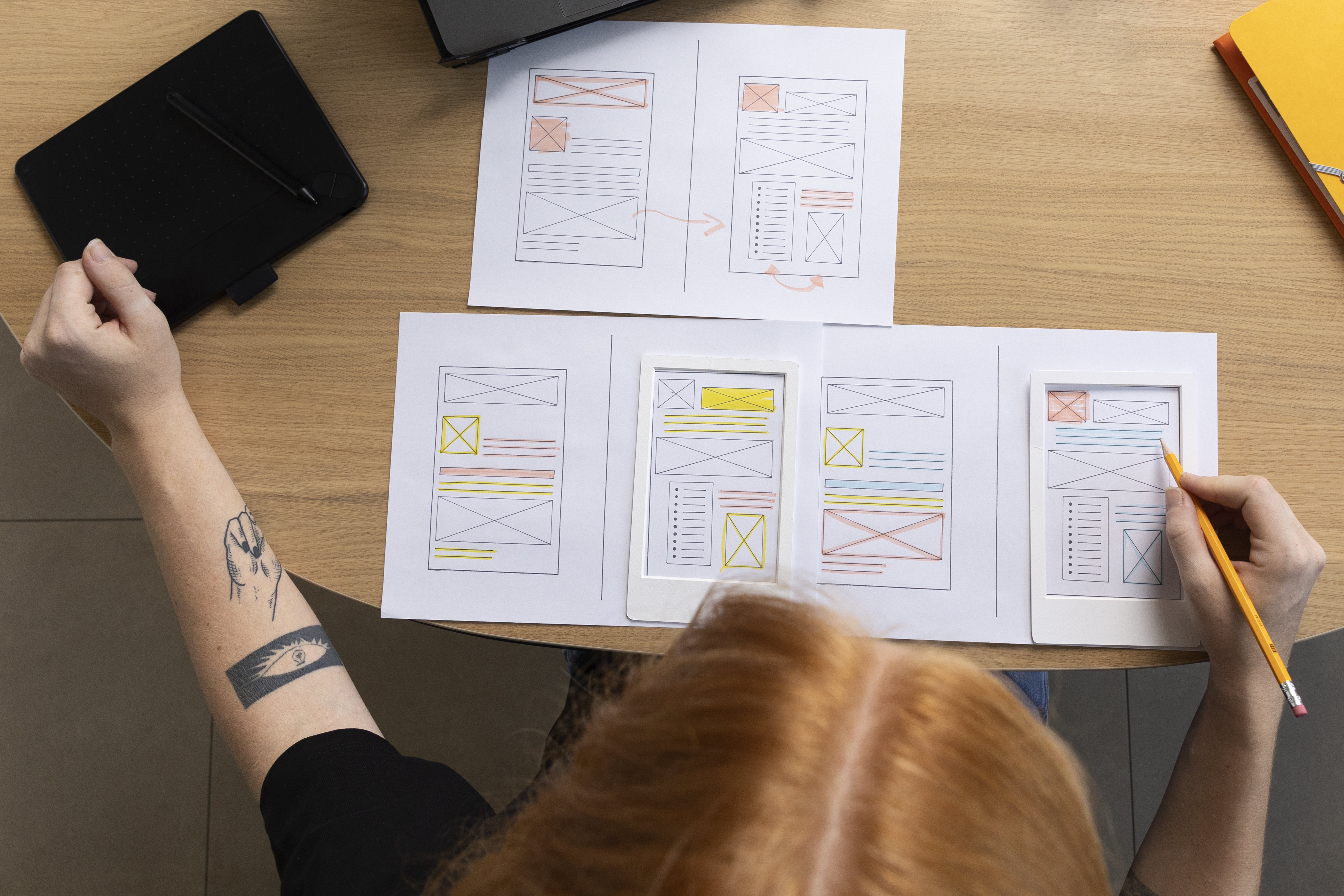 Pessoa desenvolvendo wireframes de interface de aplicativo móvel durante o processo de design de UX.